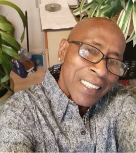 African American male with glasses smiling